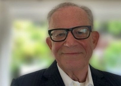 Headshot of a smiling man in black-rimmed glasses. Text reads, Jake Steinman's TravelAbility highlights the importance of accessible travel.