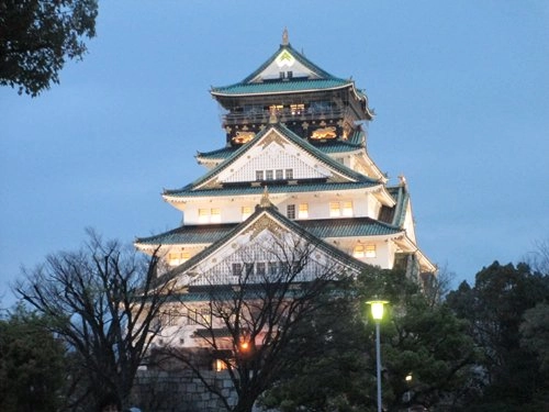 A traditional Japanese-style white building, with sloping green roofs is lit up at night. The title reads, Accessible Japan, Facilities for people with mobility. . . Read More.