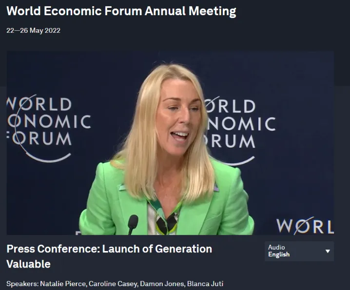 A screenshot from a World Economic Forum Annual Meeting video clip. A blonde woman wearing a bright lime green blazer is speaking animatedly into a microphone. The backdrop is a dark blue wall with the repeating white logo and text "WORLD ECONOMIC FORUM." Text beneath the image identifies the event as a "Press Conference: Launch of Generation Valuable" and lists the speakers, including Natalie Pierce, Caroline Casey, Damon Jones, and Blanca Juti.