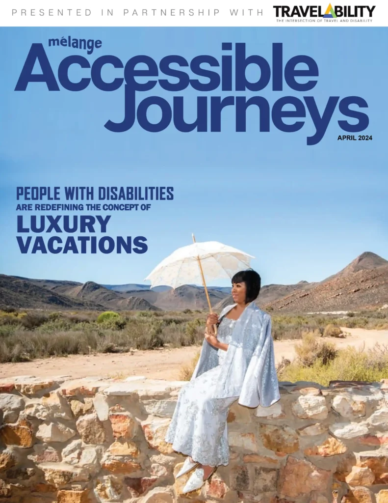 Cover of the April 2024 issue of Mélange Accessible Journeys magazine, presented in partnership with Travelability. The cover features a person dressed elegantly in a light blue outfit, sitting on a stone wall in a desert landscape, holding a white parasol. The headline reads: 'People with disabilities are redefining the concept of luxury vacations.