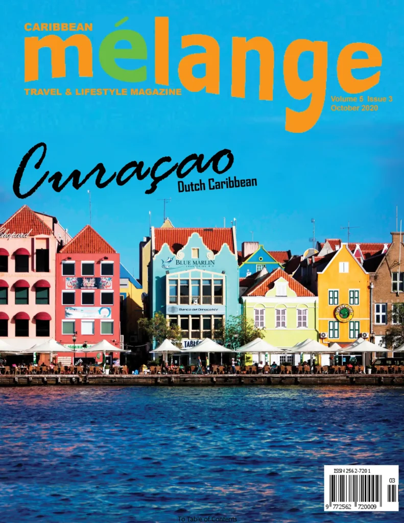 The cover features a picturesque waterfront scene of colorful, traditional Dutch Caribbean buildings in Curaçao. The vibrant buildings, with their unique architecture and bright hues of red, yellow, green, and blue, stand against a clear blue sky, creating a striking visual contrast. The title "mélange" is prominently displayed at the top in bold orange and green letters, with the subtitle "Travel & Lifestyle Magazine" in smaller orange text. The issue highlights "Curaçao Dutch Caribbean" in elegant, black cursive writing, emphasizing the location's cultural charm. This edition is Volume 5, Issue 3, dated October 2020.