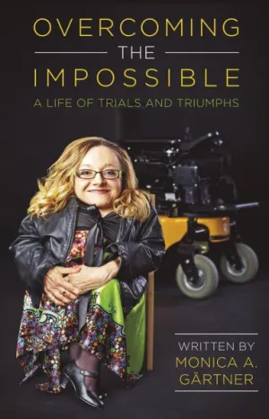 The cover of a book titled "Overcoming the Impossible: A Life of Trials and Triumphs" written by Monica A. Gärtner. The cover features a photograph of Monica A. Gärtner, a woman with blonde hair, glasses, and a warm smile, sitting in front of a motorized wheelchair. She is wearing a colorful floral dress and a leather jacket.