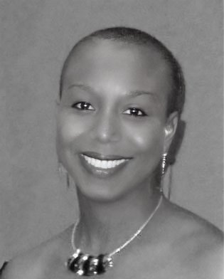 The image shows a black and white portrait of a smiling woman with short hair. She is wearing earrings and a necklace with large beads or ornaments. Her smile is warm, and she has an overall calm and pleasant expression.