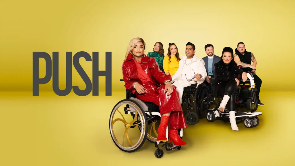 A promotional poster for the show PUSH, featuring a group of seven stylish individuals using wheelchairs against a bold yellow background. The central figure, dressed in a striking red outfit, exudes confidence as the rest of the group poses behind them.