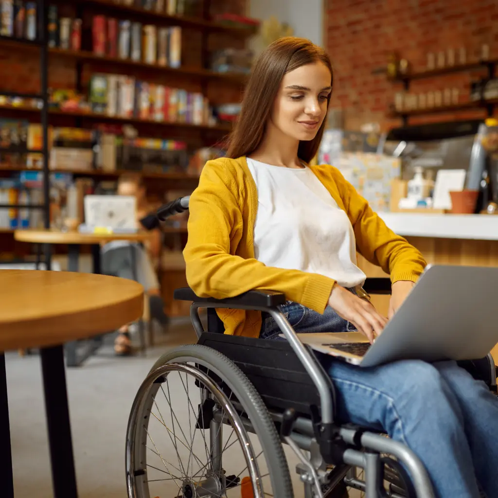 A woman in a wheelchair focused on her laptop, showcasing accessibility and technology in everyday life.