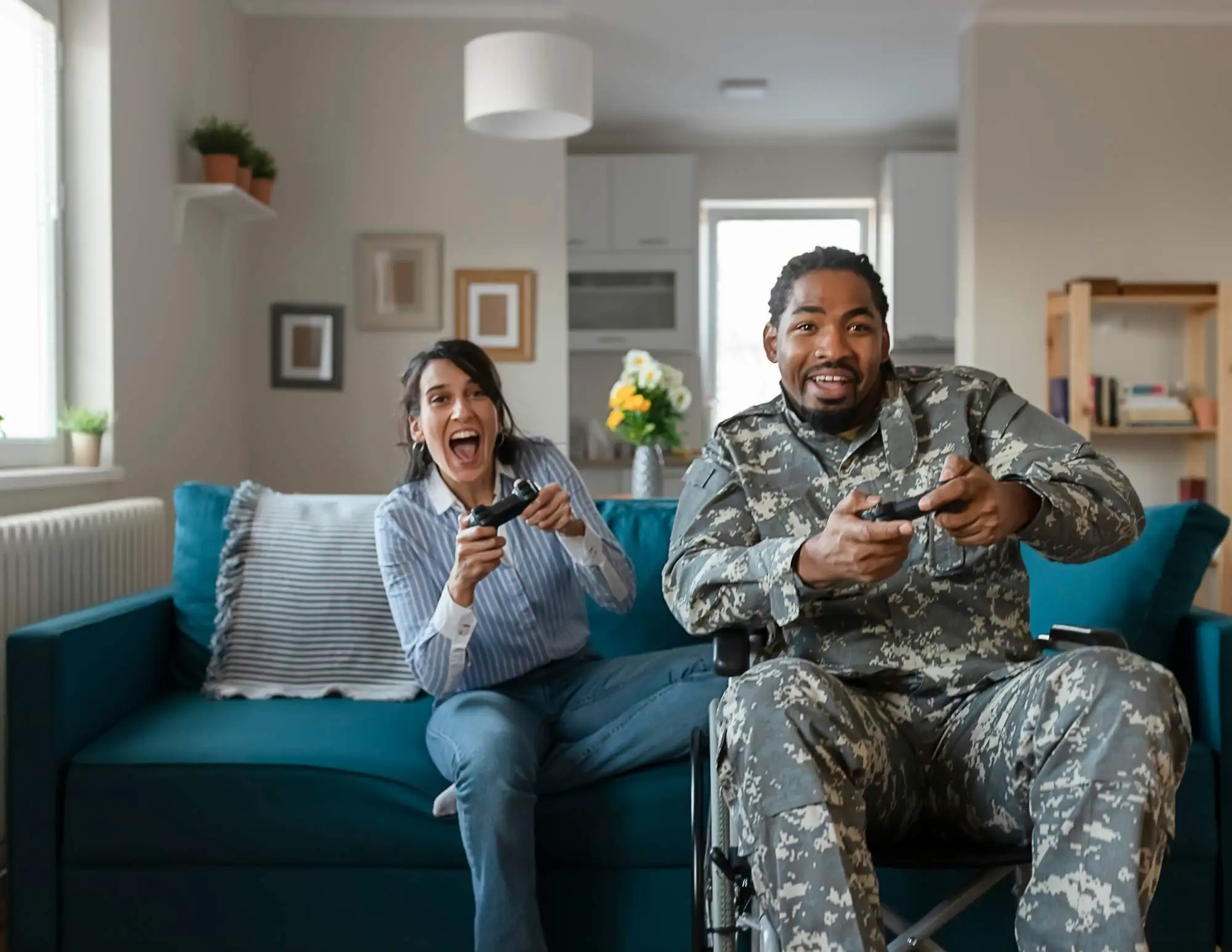 A man and woman in military uniforms engaged in a friendly video game competition.