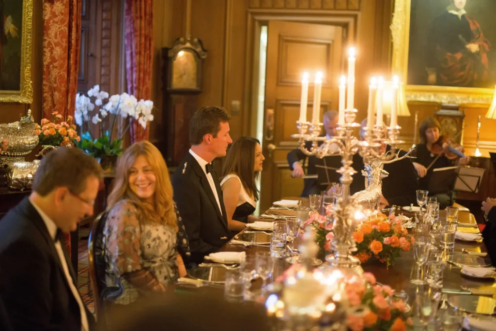 A person in a black apron chops apples on a wooden cutting board, surrounded by kitchen tools and ingredients.