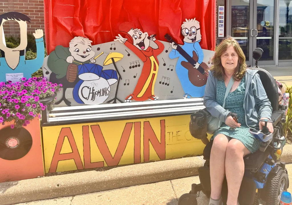 A colorful display featuring cartoon Chipmunks performing music, with vibrant flowers and "ALVIN" prominently painted below.