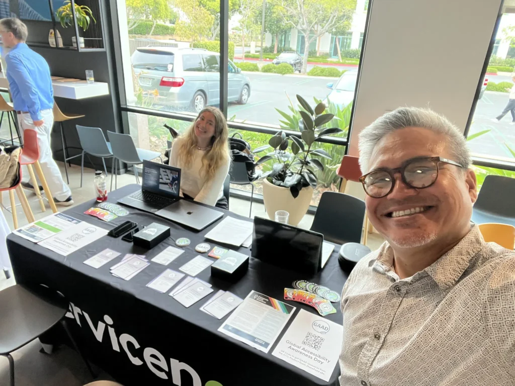 A tabletop display for Global Accessibility Awareness Day features brochures and a laptop in a bright, modern setting.
