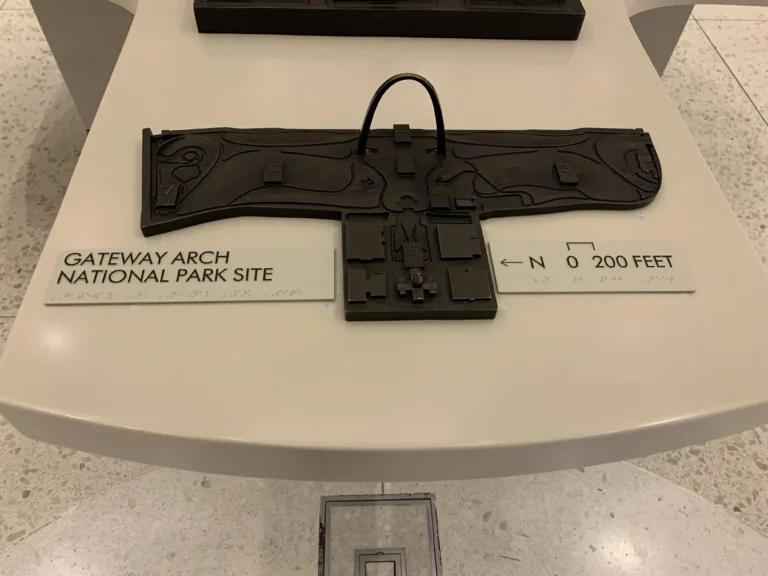 Model of Gateway Arch National Park site displayed on a table, with directional signage and labels indicating location features.