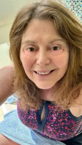 Happy woman in a floral swimsuit relaxing by the pool.