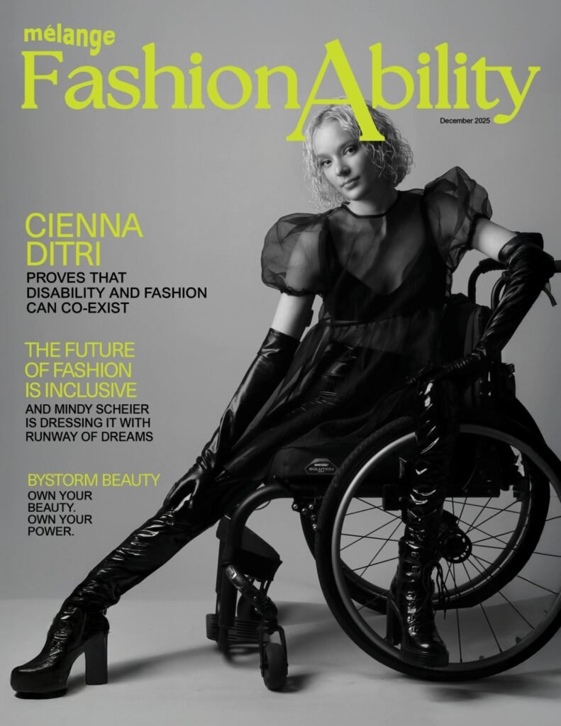 A black and white magazine cover for "mélange FashionAbility" dated December 2025. The cover features model Cienna Ditri, a young woman with short, blonde, wavy hair, sitting in a wheelchair. She is wearing a high-fashion, all-black ensemble: a sheer top with puffed sleeves over a camisole, long leather-like opera gloves, and tight-fitting patent leather boots with high heels. She poses with one leg extended forward and a confident expression. The background is a neutral grey. The magazine title "FashionAbility" and various headlines are printed in a bold, vibrant lime green. Headlines include "CIENNA DITRI PROVES THAT DISABILITY AND FASHION CAN CO-EXIST" and "THE FUTURE OF FASHION IS INCLUSIVE."