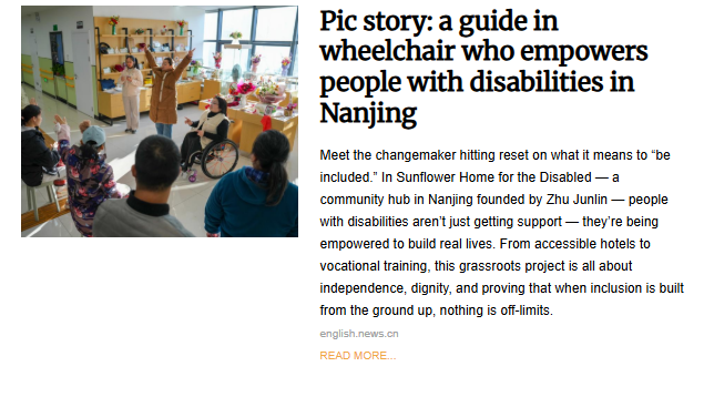An indoor scene at a community hub in Nanjing, where a person in a wheelchair and others are participating in a group activity with their hands raised, led by a standing instructor.