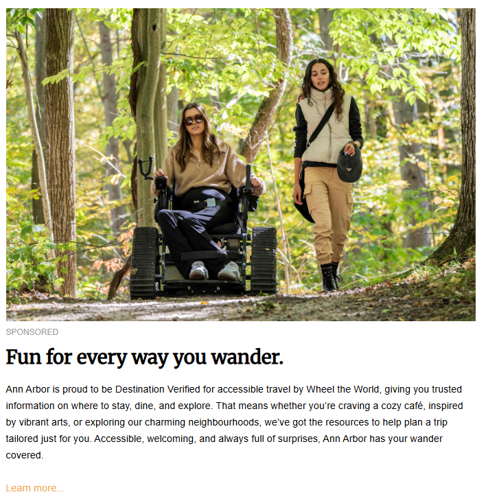 A sponsored travel advertisement titled "Fun for every way you wander." It features a woman using a rugged, all-terrain motorized wheelchair with tank-like treads, navigating a wooded trail alongside a female friend who is walking. The text highlights Ann Arbor, Michigan, as a "Destination Verified" location for accessible travel.