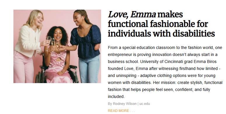 A feature article titled "Love, Emma makes functional fashionable for individuals with disabilities." The photograph shows three young women celebrating with champagne. One woman is sitting in a wheelchair wearing a silky pink dress, another is standing and wearing a blue top that shows her limb difference at the arm, and the third is standing in a white jacket and pink pants. The text explains that University of Cincinnati graduate Emma Biros founded the brand to create stylish and functional clothing for young women with disabilities.